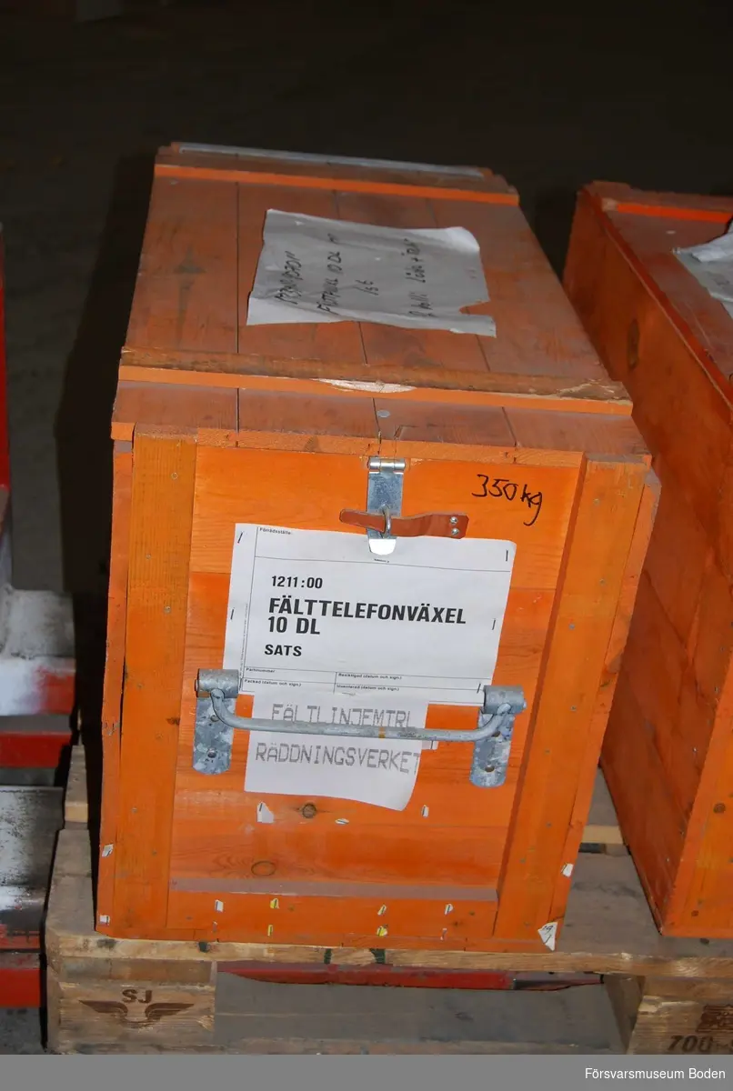Nedpackad i orange transportlåda av trä. Avsedd för Räddningsverket enligt påsatt lapp.