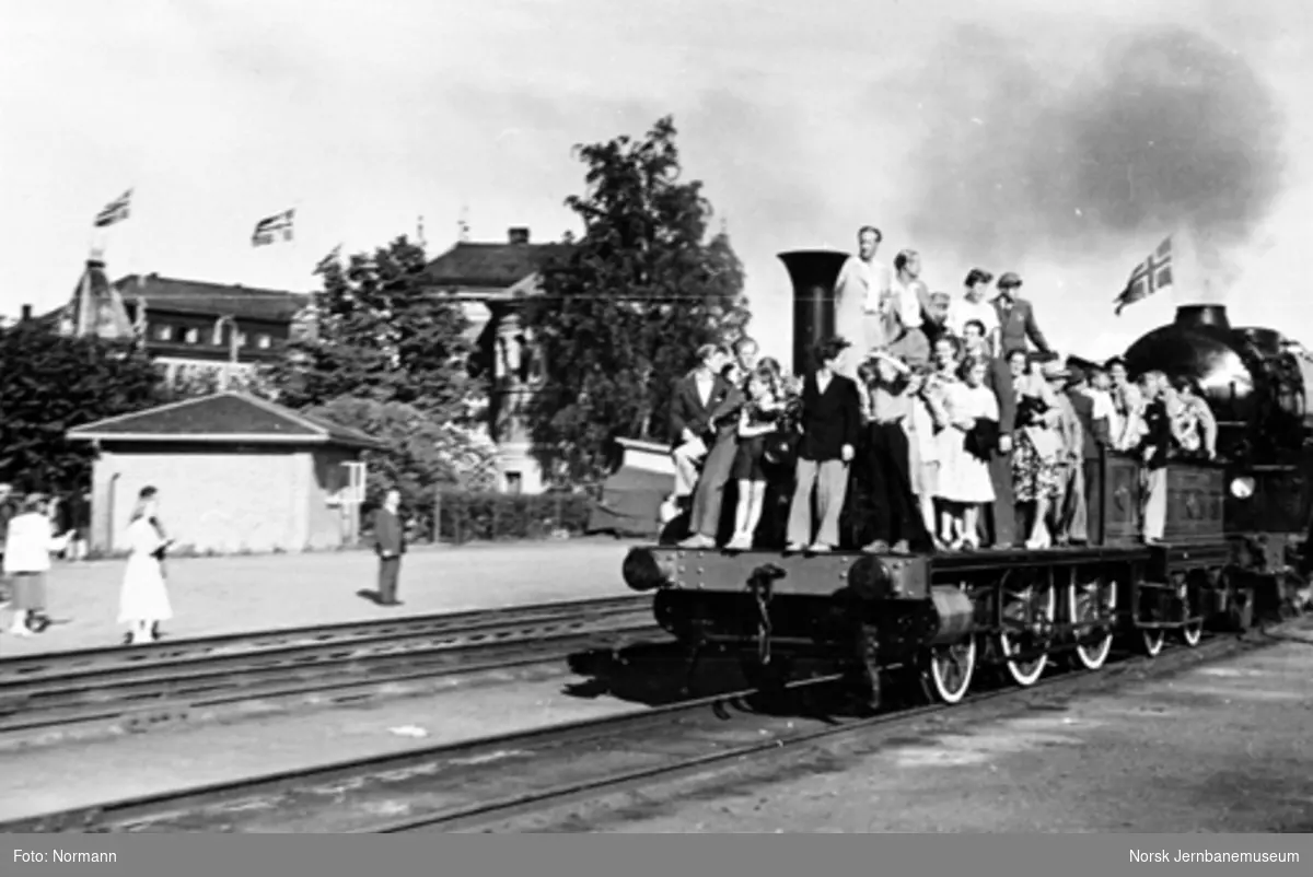 Damplokomotiv type 2a nr. 16 fullastet med jernbanefolk og reisende foran damplokomotiv nr. 471