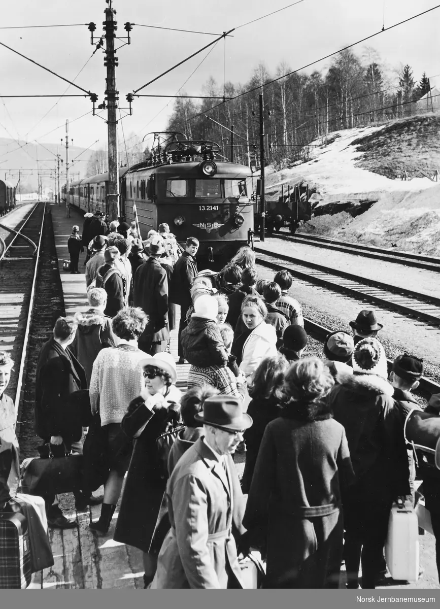 Sørlandsbanens dagtog trukket av elektriske lokomotiv El 13 nr. 2141 ankommer Bø stasjon, hvor reisende venter