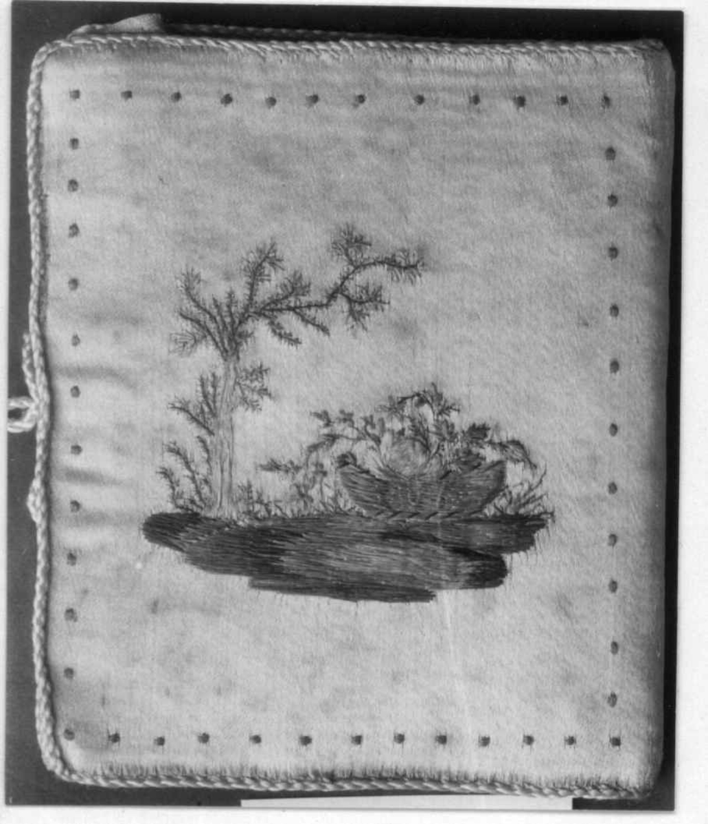 Hvitt nålebrev i silke med brodert dekor og blad av ull til nåler.