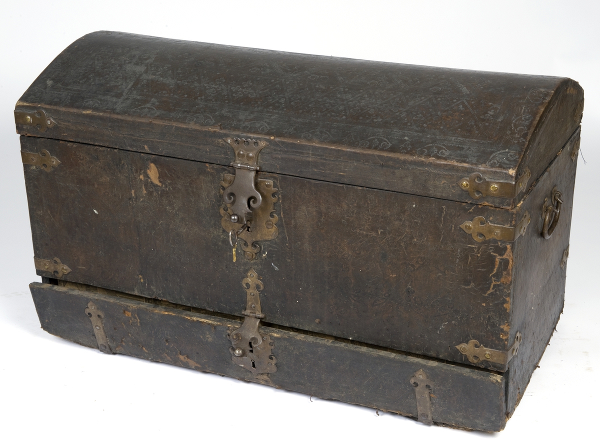 Kiste med buet lokk. Trukket med preget lær utvendig. Innvendig foret med tekstik. I fronten en låsbar skuff foret med kobberstikk med datering "Decem 1651"