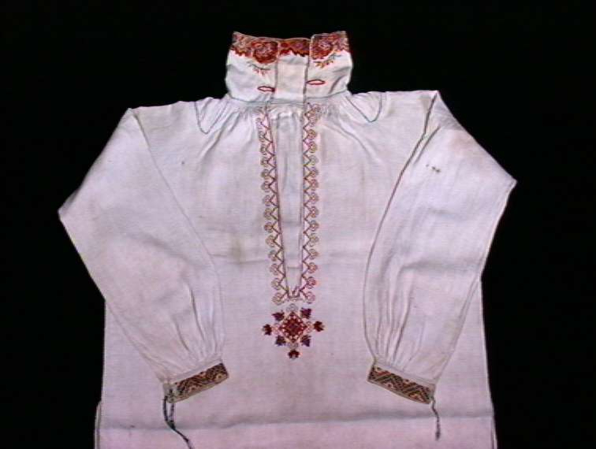 Hvit skjorte til man med brodert dekor fram, på krage og ermer. Brukt i perioden 1800-1840 til snippekuftekleda i Aust- Telemark