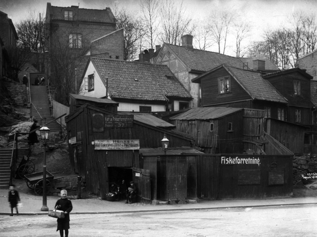 Damstredet, Oslo, 1917. Trehusbebyggelse, gatebilde med trapper, lykt og fiskeforretning.
