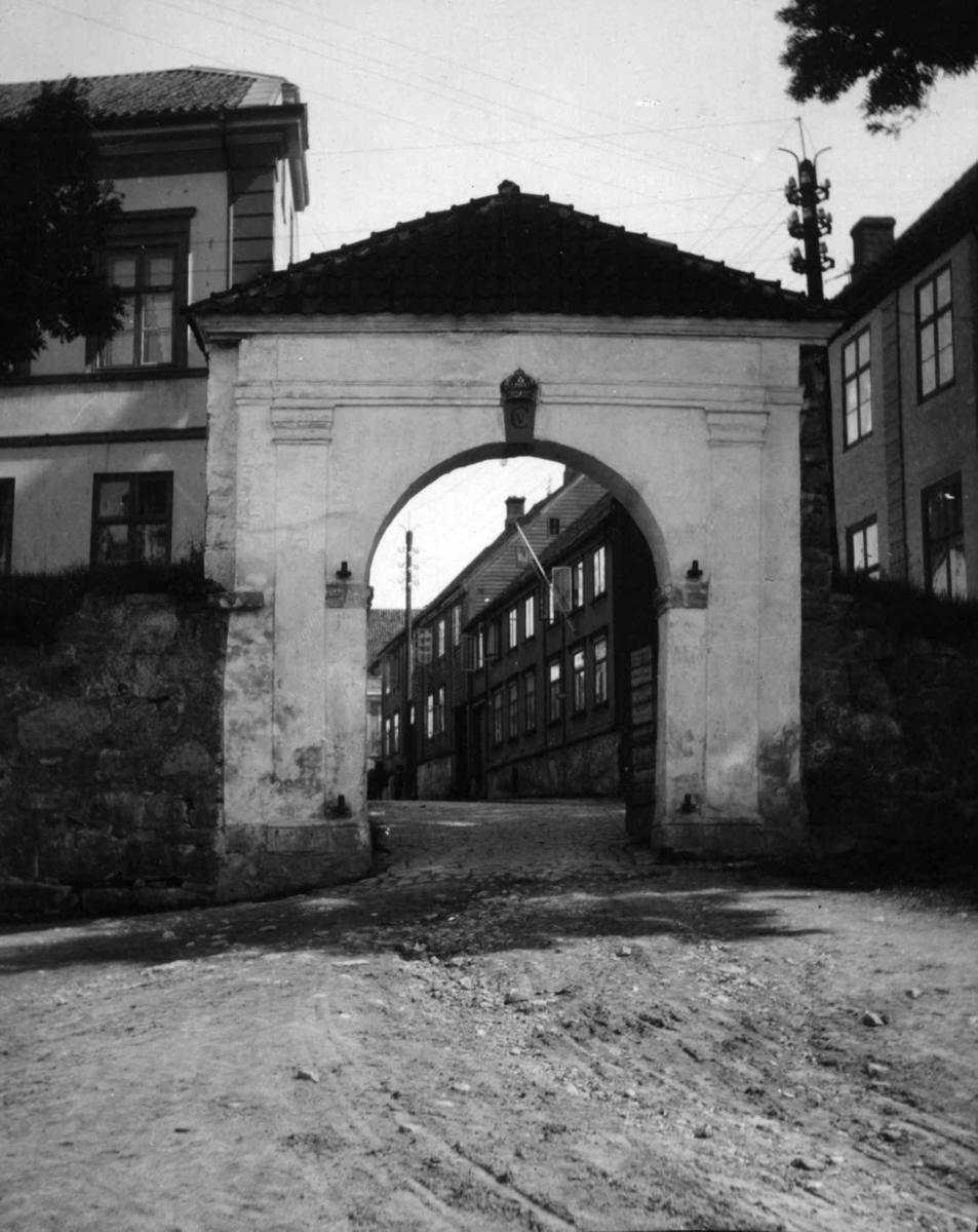 Postkort. Mellomporten, Fredrikstad. 1930. Gate med bebyggelse i  bakgrunnen.