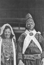 Nærbilde av brudepar i brudestas foran en inngangsdør.