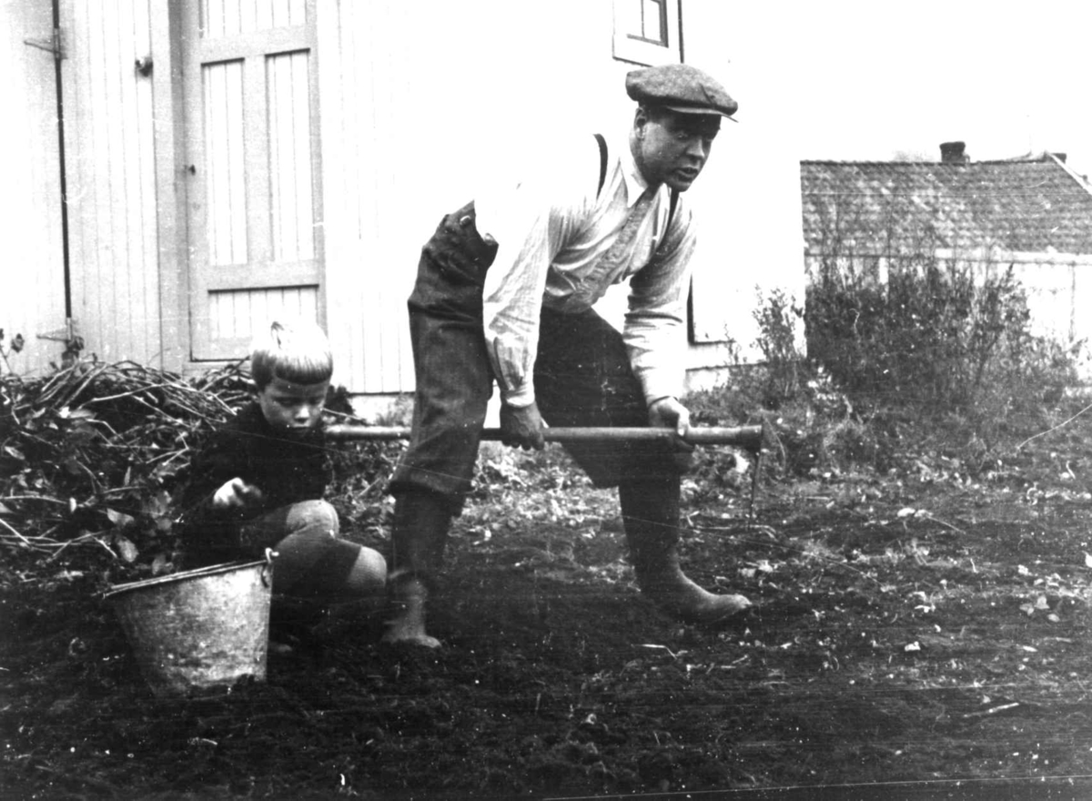 Skjåk, Oppland 1941. Mann og gutt ibber med jorda utenfor boligen.