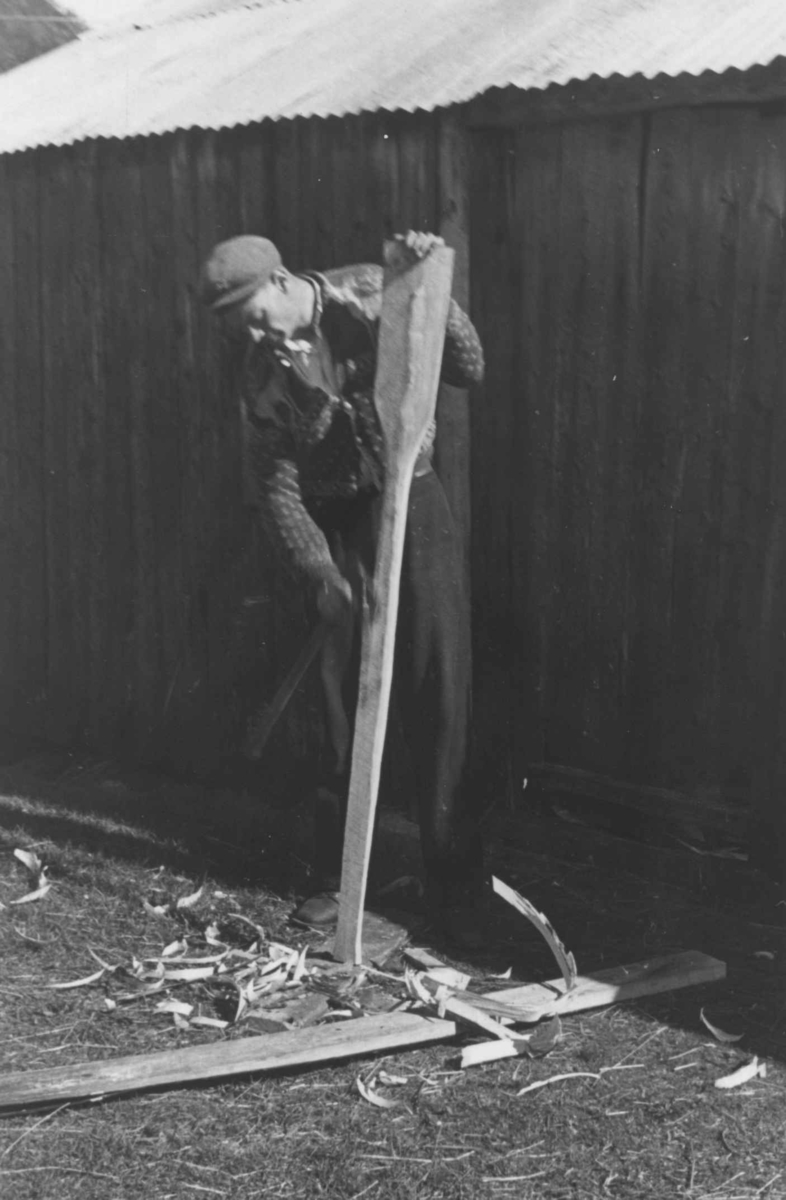 Ola Ånonsen Smeland bruker øks for å lage en åre. Åseral 1943.