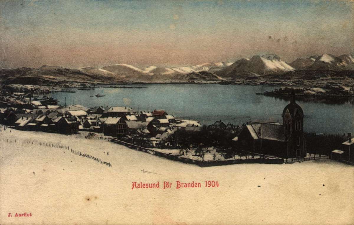 Postkort. Jule- og nyttårshilsen. Vintermotiv fra Ålesund. Før bybrannen i 1904. Bybebyggelse med kirke. Fjord med
båter.