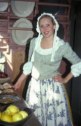 Vert i bydrakt i kjøkkenet med mat på bordet i Chrystiegårde