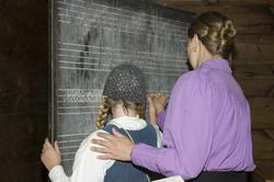 Levendegjøring på museum.Ferieskolen uke 31. Elev skriver p