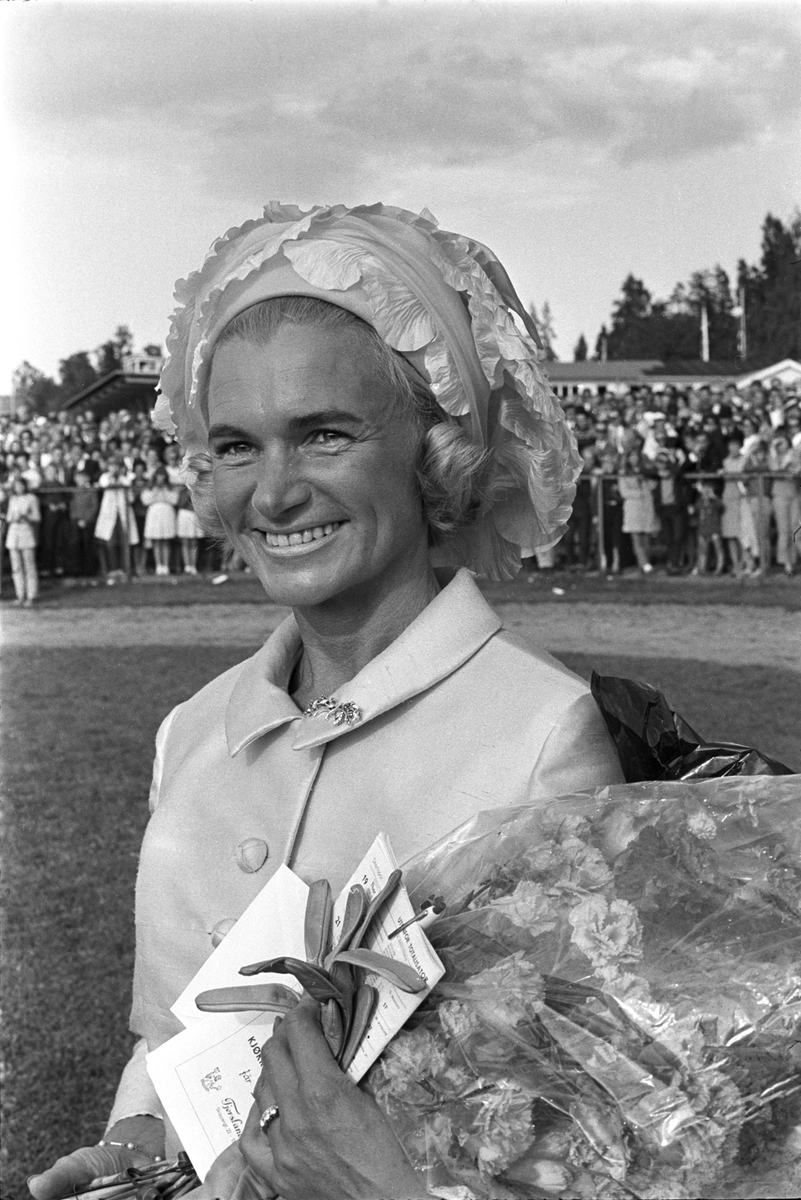 En av deltakerne i damenes hatteparade har fått overrakt en blomsterbukett under Norsk Derby på Øvrevoll galoppbane i Bærum 20. august 1967.