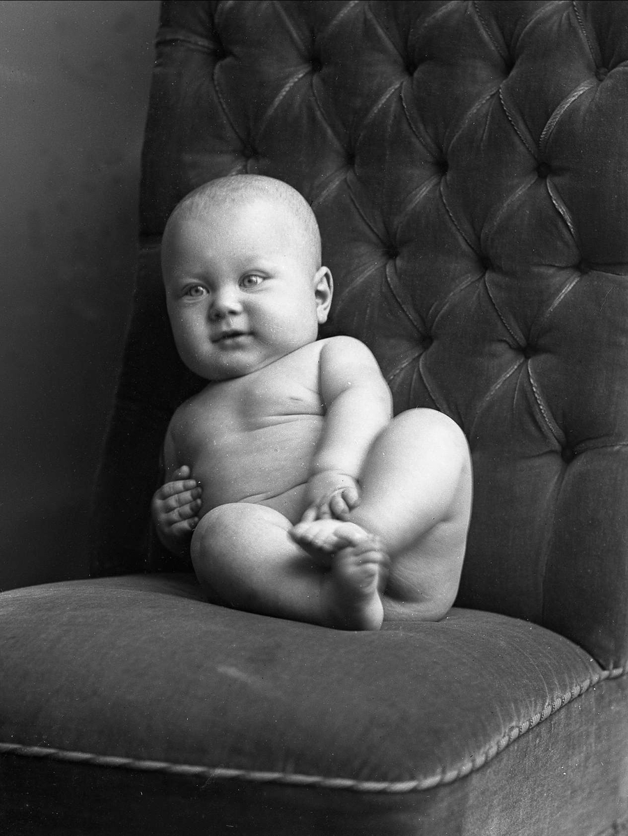Portrett, nakent spedbarn på en stol. Fru Murmester Kristensens barn.