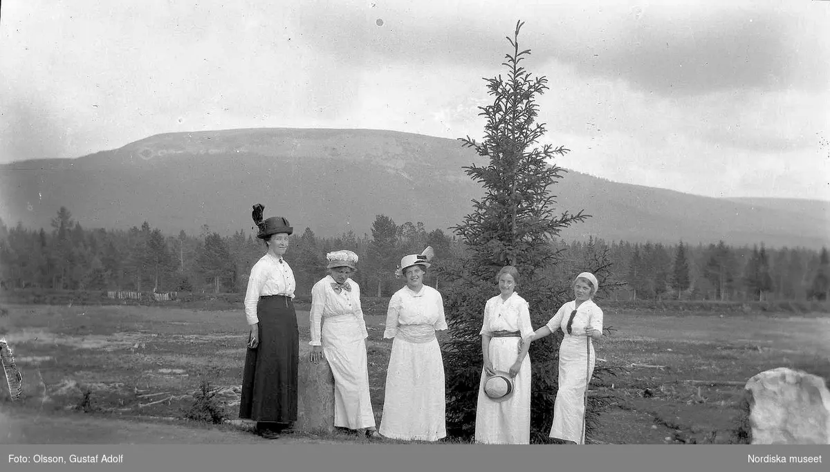 Gruppbild av fem kvinnor med  utsikt över ett berg i bakgrunden. 1900-talets först hälft.