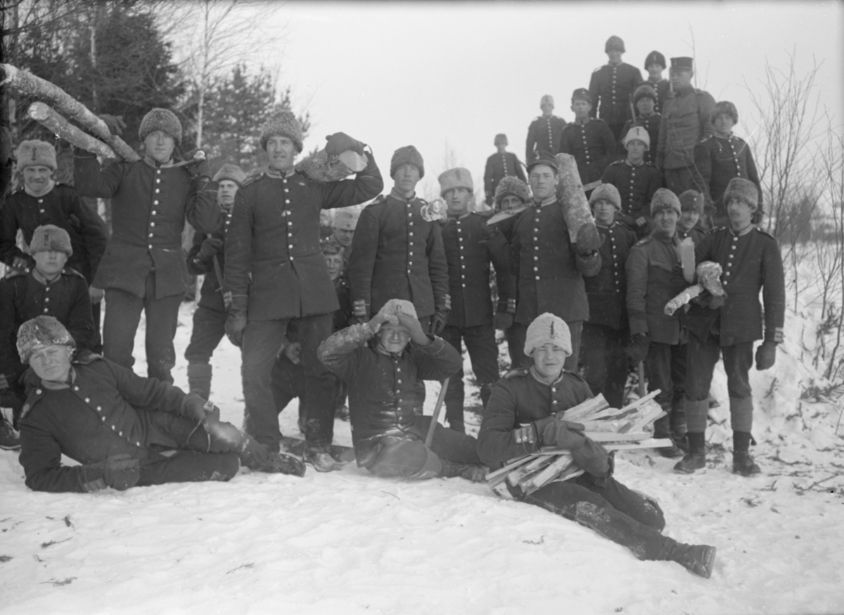 Grupporträtt. En större samling armésoldater från I 4 och / eller I 5 regemente samlar ved, vintertid.