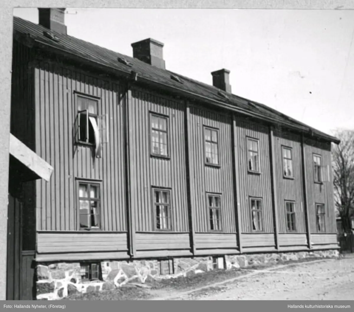 Äldreboende. Kv Åkaren 13. Bostad. Bilden har varit publicerad i Hallands Nyheter, 1947-12-04, "Pensionärshemsbygget  på "Reträtten" har påbörjats". Byggnaden, som uppfördes 1864 efter den stora stadsbranden året innan, fungerade som nödbostäder för de hårdast drabbade. Ganska snart efter kom det att fungera som ett fattighus. Det revs1947 och på rivningstomten uppförde staden sedan pensionärshem med 48 små lägenheter.