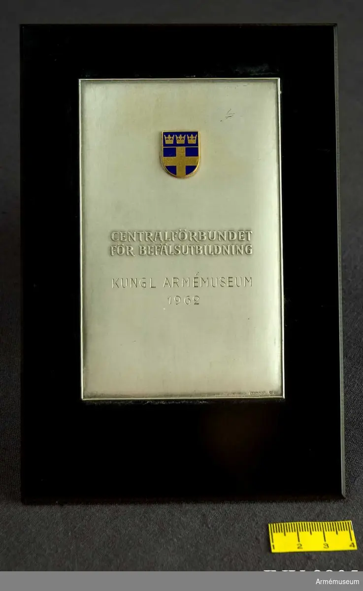 På den bakelitmonterade plattan, utförd i matt silver, är fästat FBU:s märke i blå emalj och guld. På frånsidan finns en ögla för upphängning.