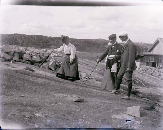 Enligt text som medföljde bilden: "Professorskan Calla Curman pekar indignerad på misshandlade hällristningar av stenhuggare i Brastad. Thor och Gerhard Odencrantz c:a
1907."