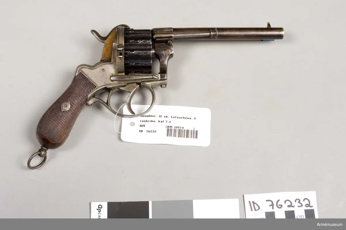 Grupp E III.
Revolver med en pipa och patrontrumma för 12 skott. Märkt system Lefaucheux. Fabriksnummer 4162 eller möjligen 4167; den sista siffran otydlig. Pipan är 13,7 cm låmg och rund.