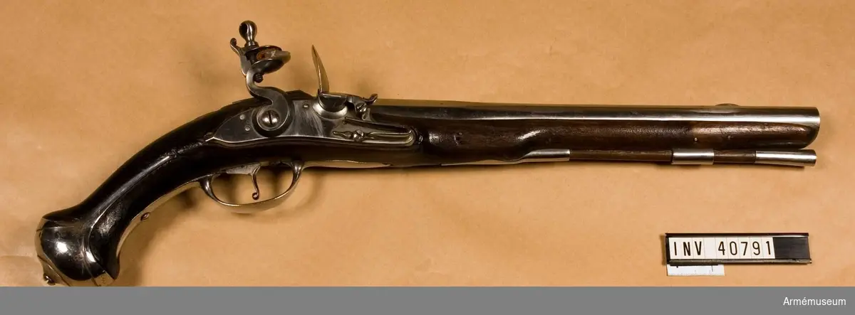 Grupp E III.
Pistol från 1700-talets början. Loppets relativa längd: 19,1 kal. pistoler bildande namnchiffer på vänstra kortväggen i II:2.