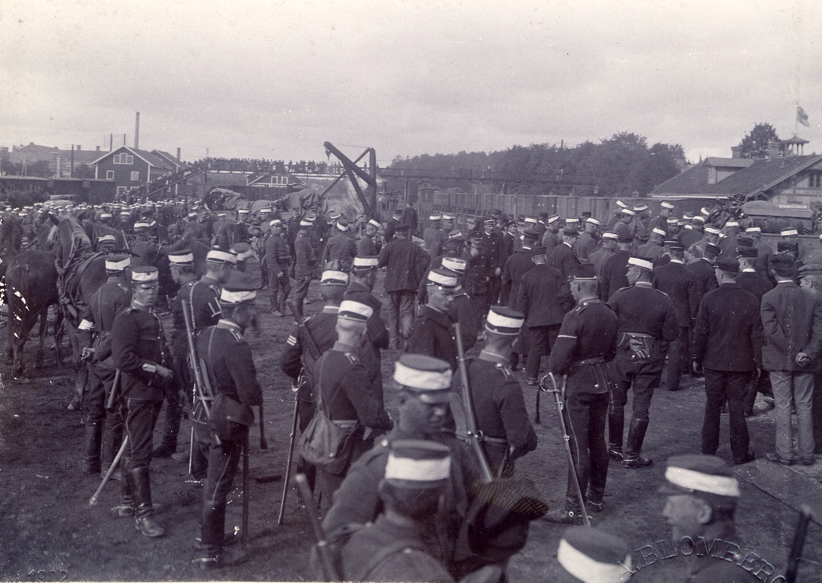 Göta livgarde I 2, lastar av  vid Katrineholms järnvägsstation inför marsch 1902. Manskapet har vita bindlar på mössan.