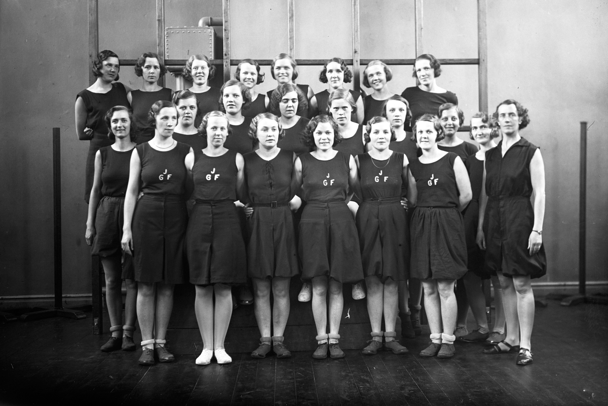 Jönköpings Gymnastikförening (JGF) i Västra skolans (nuvarande Talavidskolan) gymnastiksal. Föreningen bildades 1918.
Bakre raden: Astrid Nilsson g. Svensson(1), Rut Gran(2), Ingeborg Bruhn g. Bjurvik(3), Inga Örsell(4), Anna Lisa Brodén(5), Kerstin Henriksson g. Norman(6), Svea Eng(7), Rut Gustafsson(8).
Mellersta raden: Iris Lindblom(1), Margit Augustsson(2), Inga Lisa Holmér(3), Astrid Sandblom(4), Greta Nyström(5), Britta Andersson(6), Magnhild Augustsson(7), Stina Larsson(8).
Främre raden: Anna Andersson(1), Stina Vestberg(3), Elsa Holm g. Wallin(4), Gullan Johansson g. Nydén(5), Sonia Hellman(6).
Längst till höger ledare Marianne Herrlin.