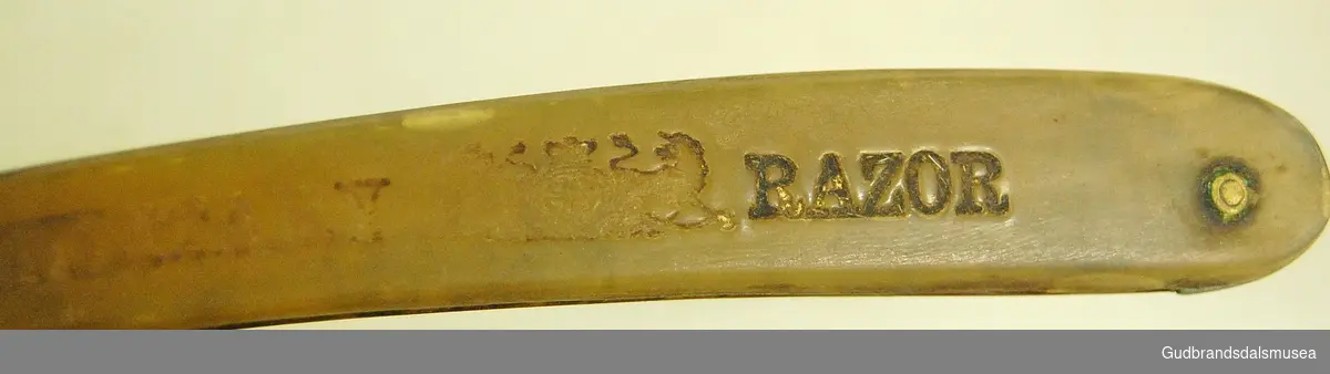 Sammenleggbar barberkniv i stål, med håndtak av bein, håndtak lett buet. Knivhals naglet til håndtak. 