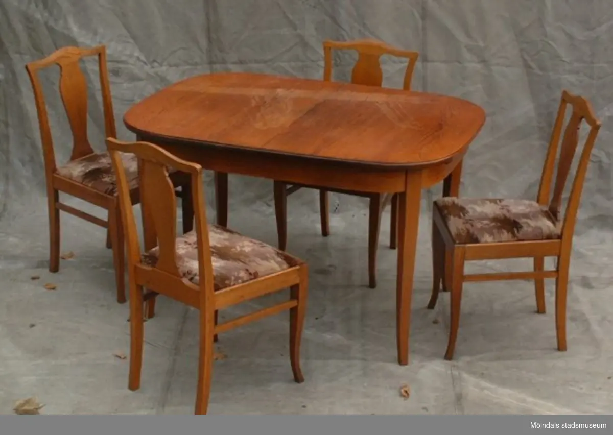 Matsalsmöbel, bord och fyra stolar i brunbetsad björk.
Samtidigt förvärvades 1 st bäddsoffa i mörkbetsad björk 02115.