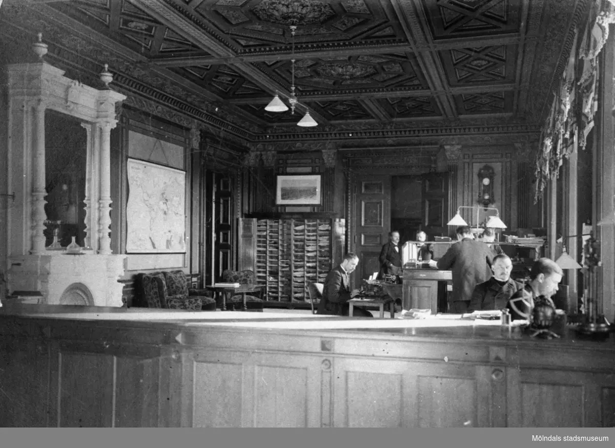Interiör från kontoret i Papyrus villa i Mölndal år 1895. Sju män som arbetar.
