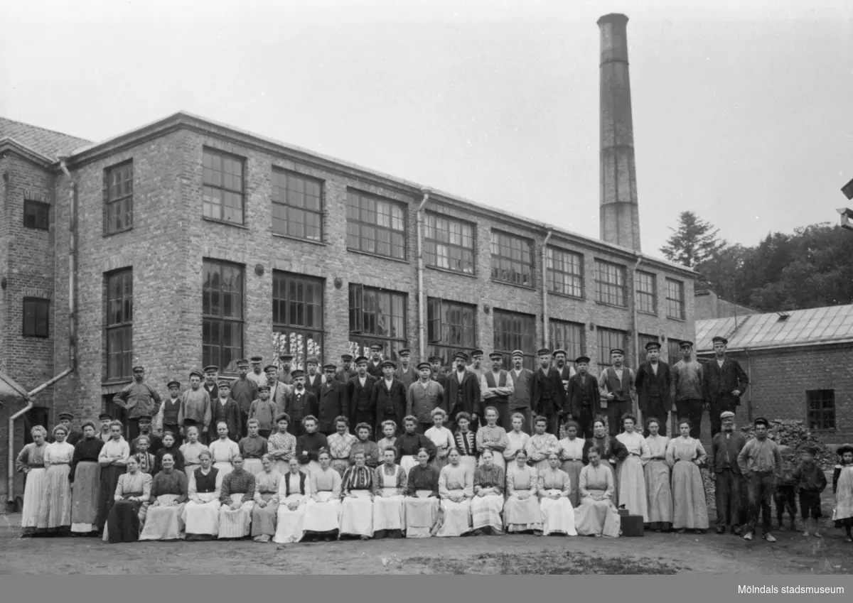 Arbetsstyrkan, vid Anderstorps fabriker, sitter eller står framför nya spinneriet (byggdes 1907). 1920-tal.