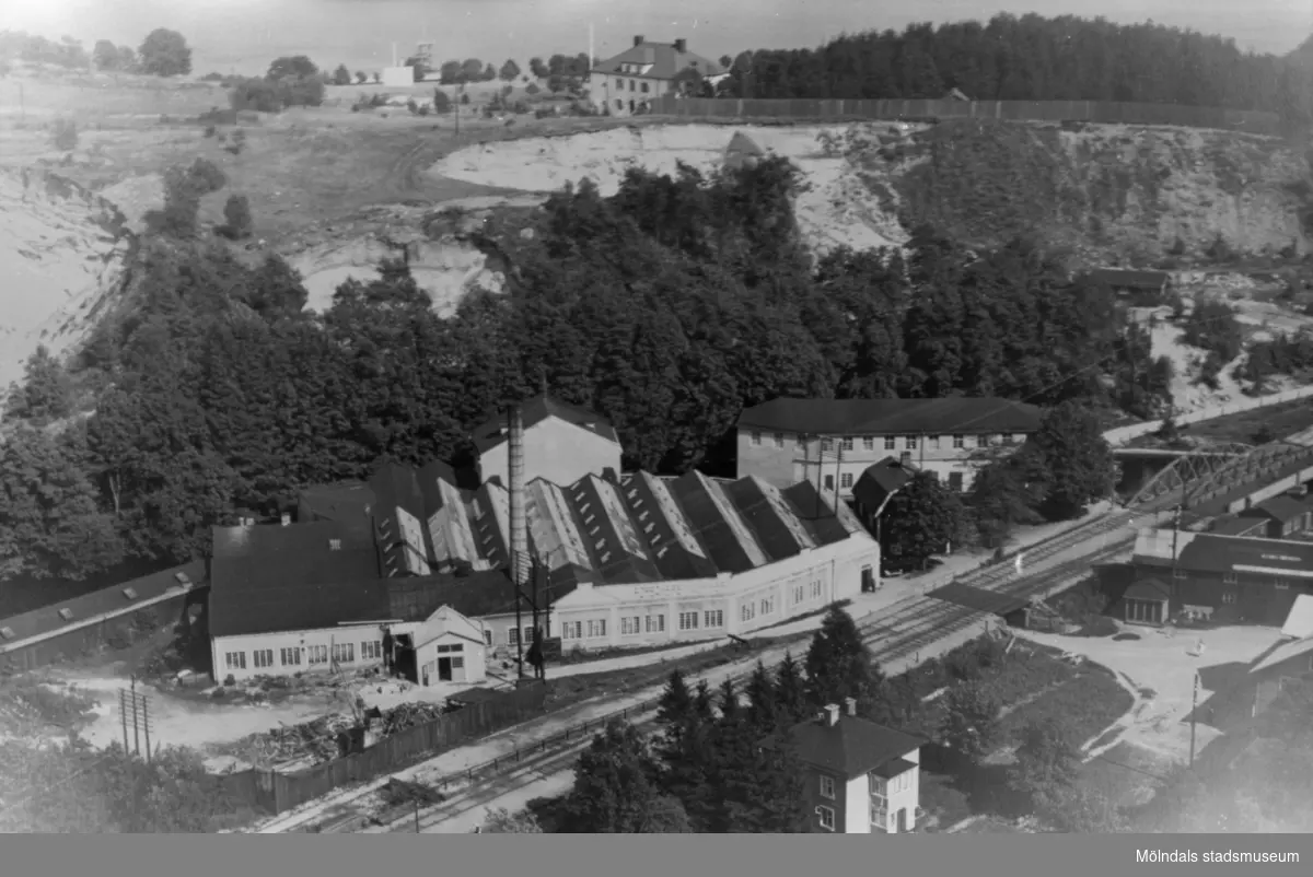Flygfoto över Forsåkers fabriker vid Grevedämmet i Mölndal, 1930-tal. I bakgrunden ses Stensjön och Stensjöhill. Fabriksbyggnaden kallades tidigare för Bettyholm och Carlsfors fabriker.