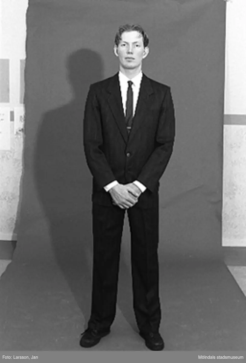 Joakim Hjalmarsson iförd kostym använd av personalchef på Volvo. Inför utställningen "Krinoliner och kortkort" på Mölndals museum.