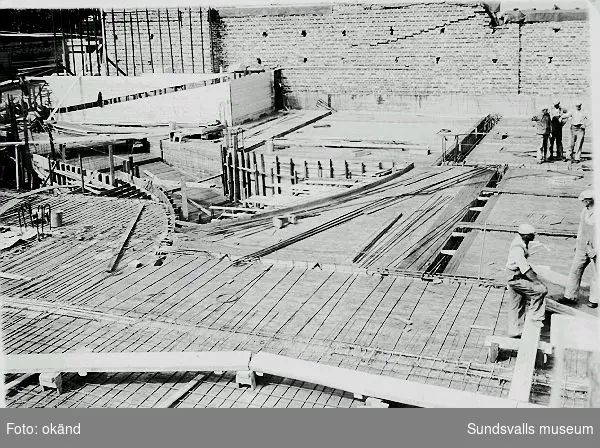 Armeringsarbete vid byggandet av Philipsons bilaffär, Norra Järnvägsgatan 8, 1939-07-12. Bland betongarbetarna finns bl.a. Erik Edblad (f. 1908). Han var verksam som anläggnings- och betongarbetare och senare som yrkeslärare i betong-och hållfasthetslära.