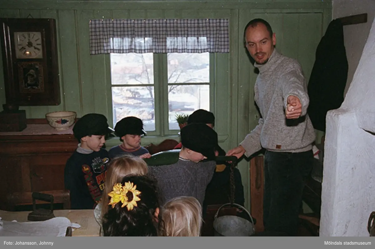 Håkan Strömberg (till höger) visar förskolebarn Olas stuga 1999-02-18. Tema: Livet förr.