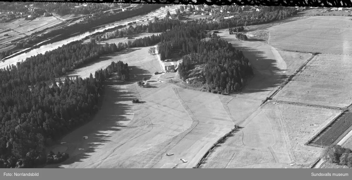 Flygfoton över Skottsunds golfbana med omgivande bebyggelse. På båda bilderna syns golfbanans klubbhus, på bild två före detta Skottsunds barnhem i centrum vid Skottsundsvägen. Längre upp i bild Junivägen och Kråksta tjärn. I övre högra delen av bilden tre gårdar som fortfarande (2016) finns kvar.