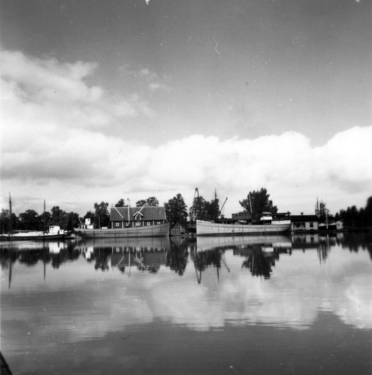Varvet med magsinsbyggnad, mastkran och kontorsbyggnad sett från kanalen, aug 1954