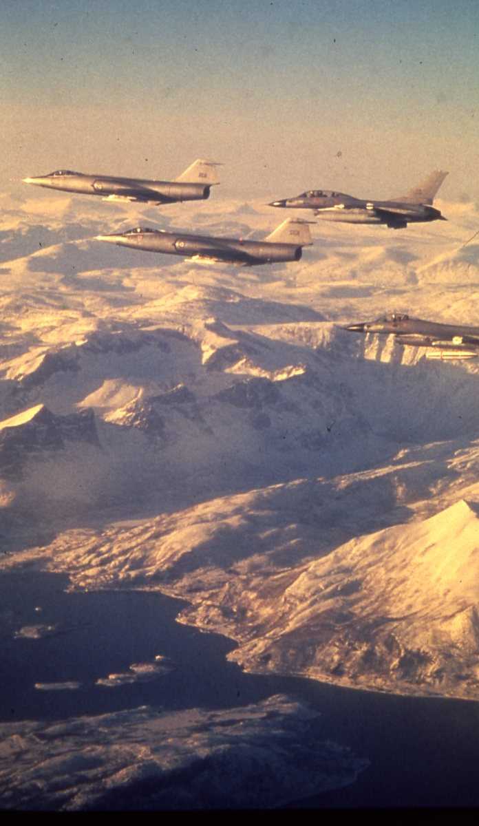 Norske F-104G Starfightere (fremst) og F-16 Fighting Falcon jagerfly flyr i formasjon.