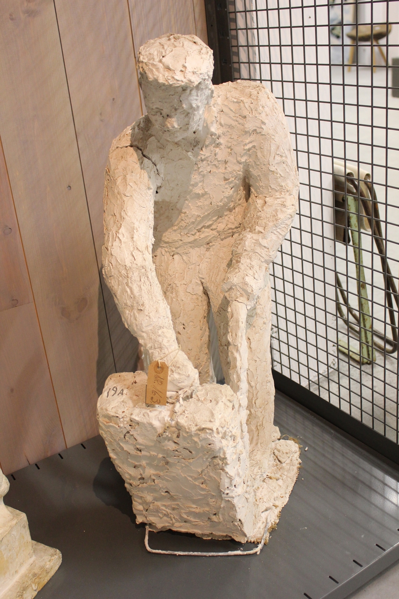 Skulptur i gips av en mann/ sjauer med tralle. Tittel: "Bryggesjaueren". Utkast til monument i Drammen. Se nr.81