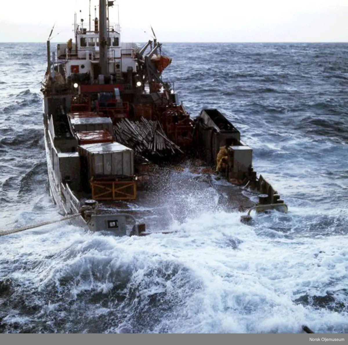 Supplybåten "Holstentor" i store bølger. Mannskapet jobber mens bølgene slår over dekk.