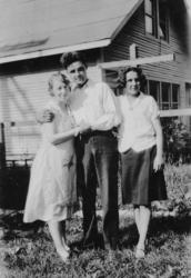 Amatørportrett av to kvinner og en mann foran et hus i Ameri