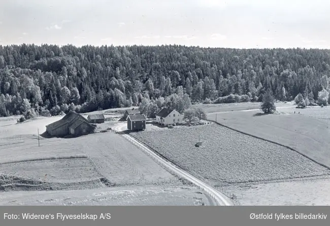 Skråfoto av gården Lundsbakken i Rakkestad, 10. august 1956.
Daværende eier Karl Lundsbakken.