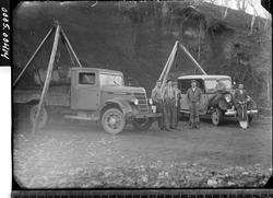 To lastebiler med stubbebrytere og arbeidskarer med spade i 