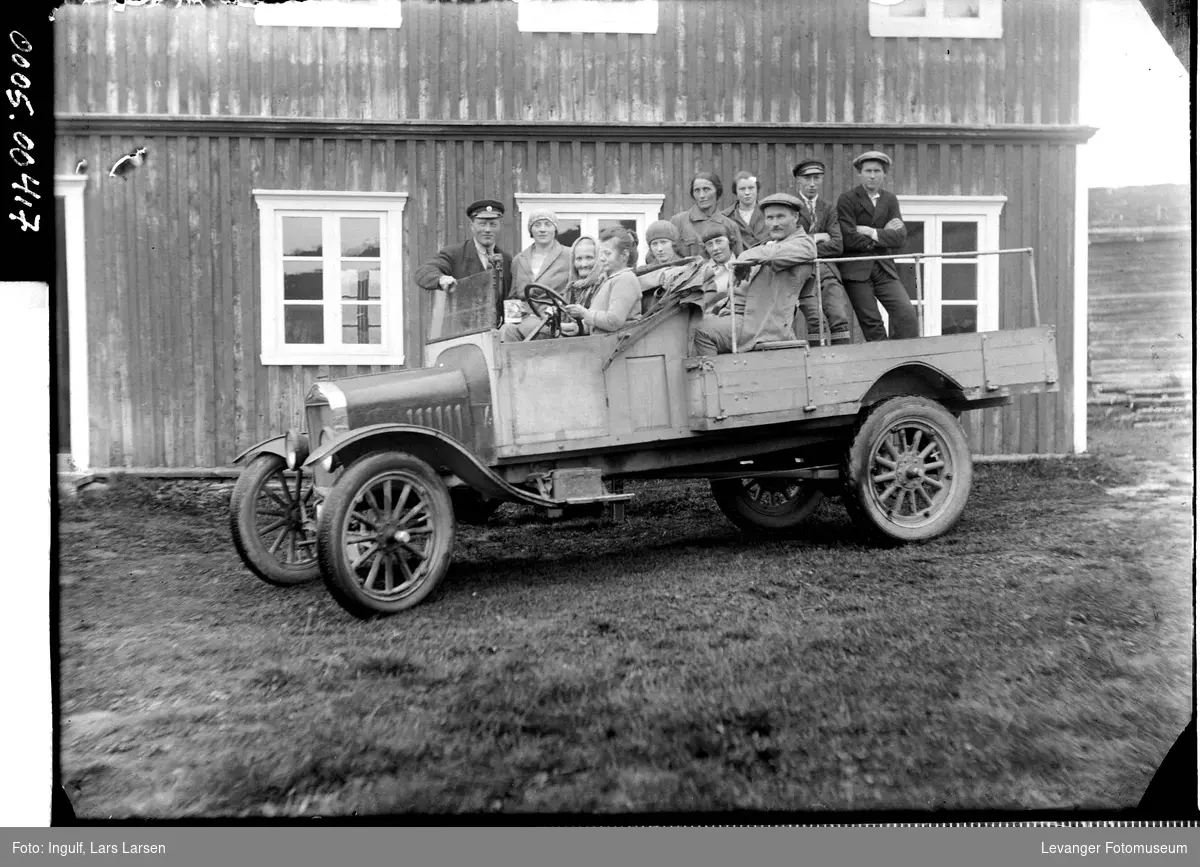 Lastebil med rned en gruppe mennesker i førehuset og på lasteplanet,  bilden er en Ford TT ca 1924-27,