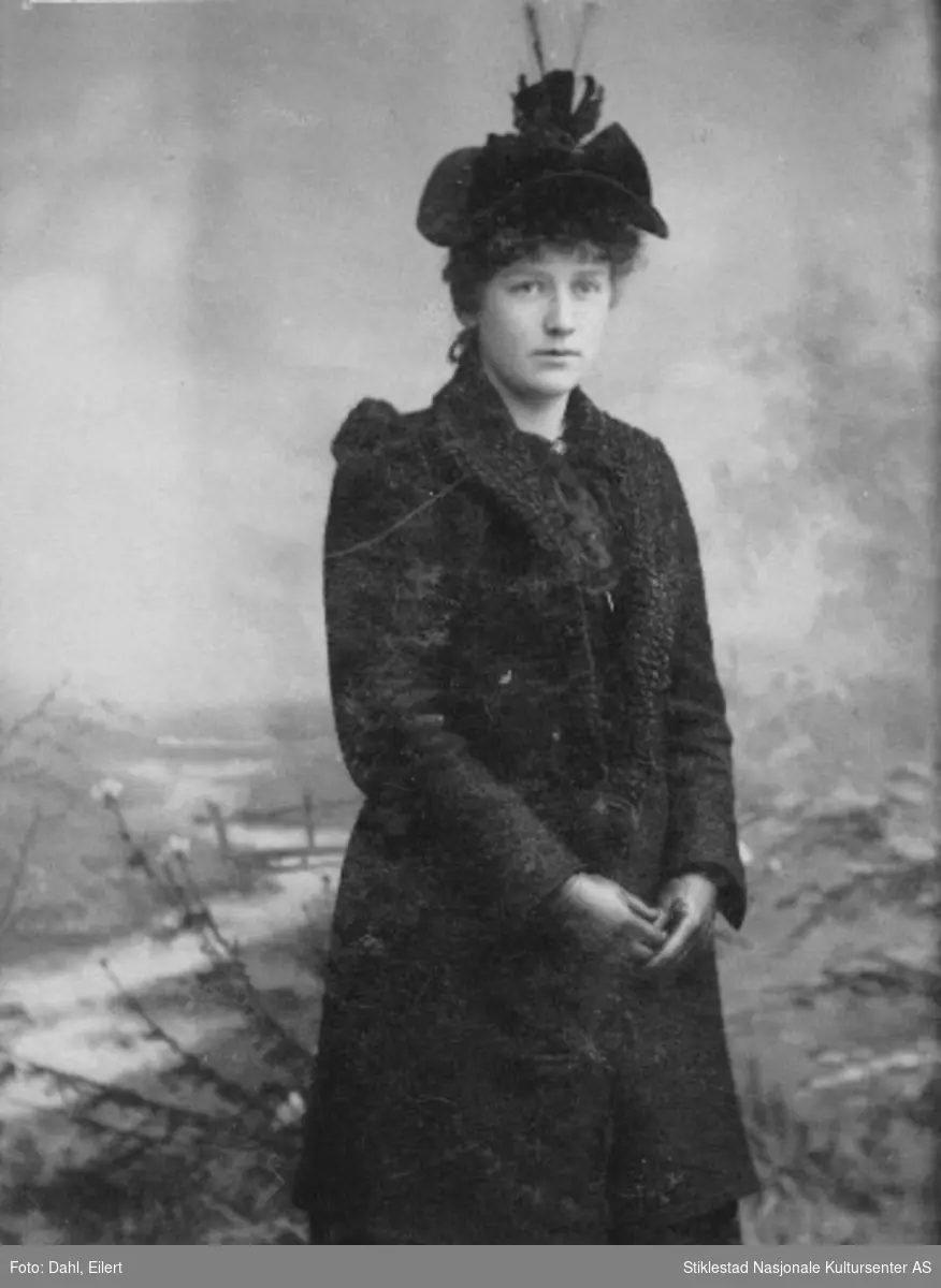 Portrett av ukjent kvinne i mørkt yttertøy/kåpe, hansker og hatt