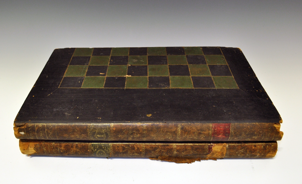 Brettspill utformet som 2 bøker - med sjakkbrett på utsiden og backgammon på innsiden. "Enderyggen" på "bøkene" i bokhylla er lærtrukket. Det samme er sjakkbrettet og backgammon-spillet. Inni ligger det én ødelagt sjakkbrikke av elfenben - den mangler hodet (se bilder). Det står "RAPINS HISTORY ENGLAND" bd. 1 og 2 på "bokryggene".