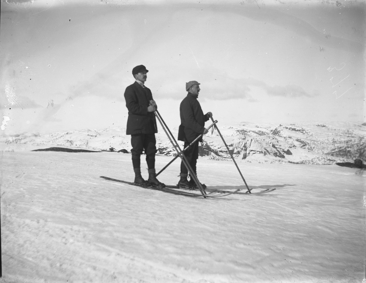 To menn på ski, fjell bak
