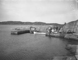 Voksne og barn, småbåter ved brygge i skjærgården. Skjørsvik