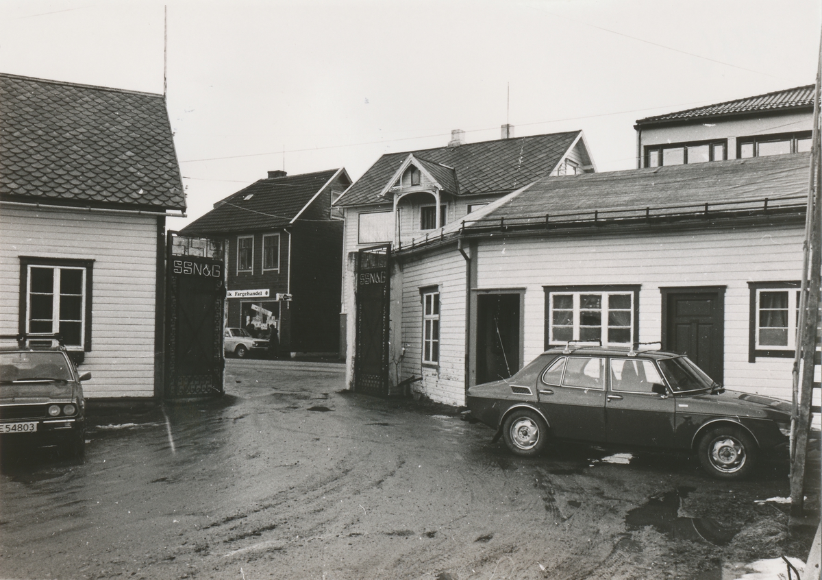 Inspektørbolig til venstre, hovedinngang og kontorer til høyre ved Spilkevigs Snøre- Not- & Garnfabrik. To biler står parkert utenfor. Bilen til høyre er en SAAB 99.