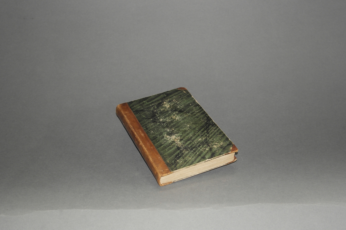 Innbundet med grønne papp- permer og skinnrygg, gullskrift i ryggen. Boka har 188 sider.