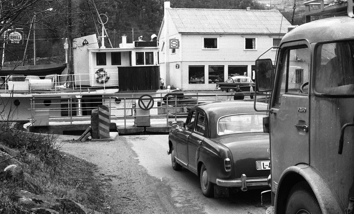 Slusene i Skjoldastraumen. Operatør i arbeid med å åpne og stenge slusene. Biltrafikken har stoppet opp i påvente av at fiskebåten "Sørbu" fra Farsund skal passere.