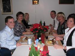 Ansatte har pyntet seg og spiser julemiddag med fint pyntet 